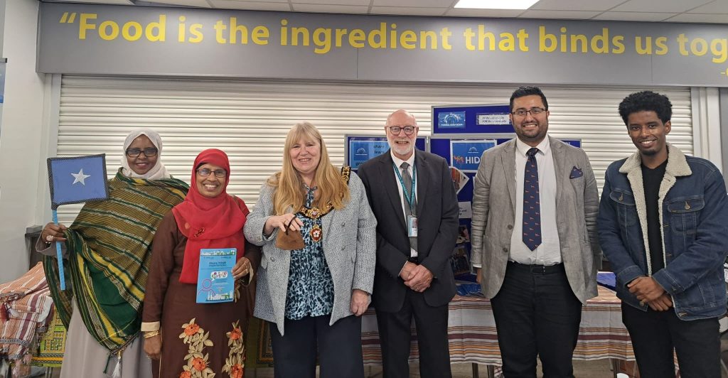 Members of the Hiddo group stand proudly with the Lord Mayoress, Rishi Madlani, and Yahye Abdi, celebrating the unity and diversity of Leicester at the Somali Festival, where food, culture, and camaraderie are the ingredients that bind the community together